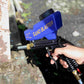 Blue sand blaster gun held in hand with nozzle spraying over outdoor surface