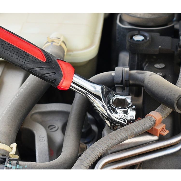 Socket wrench in engine compartment with chrome ring head and red-black handle