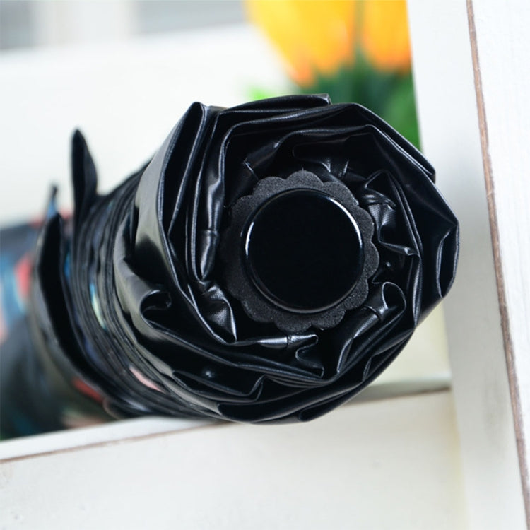 Folded black umbrella with rosette-style fabric wrap detail