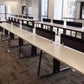 Desktop office partition screen held by silver clips along conference table
