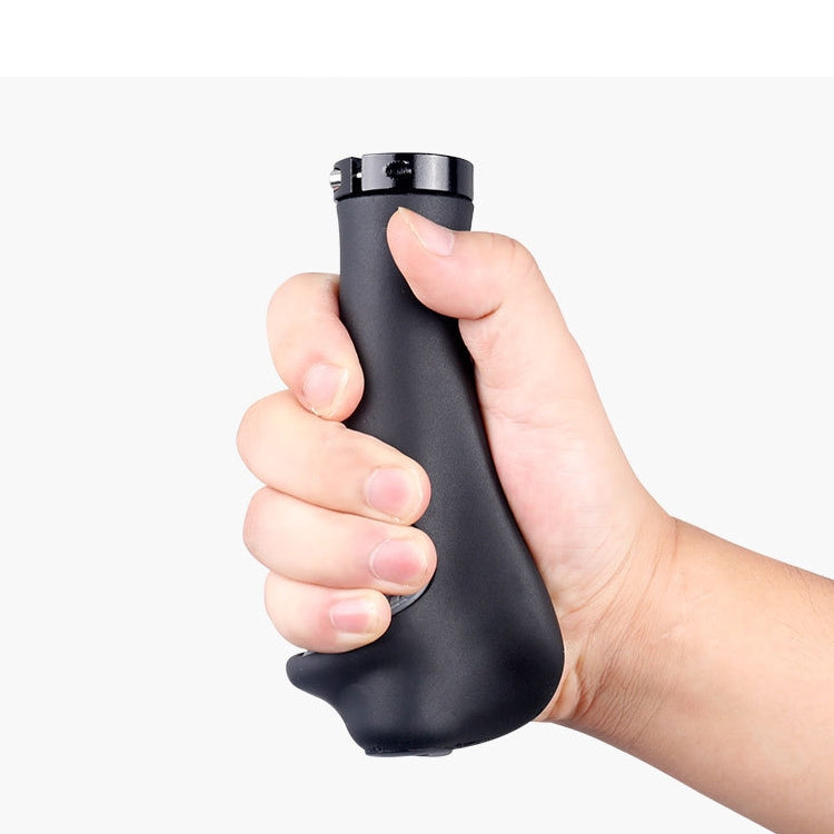 Hand holding black mountain bike handlebar grip with gray textured palm pad