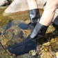 Navy adult shoe covers worn over bare legs while standing in shallow water