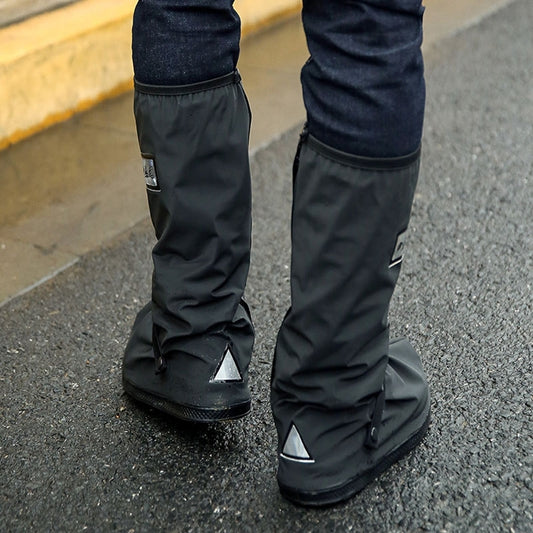 Black tall rain boots with fold-over top and logo patch, lower legs visible.