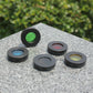 1.25-inch telescope color filters assorted on a stone surface, green and blue visible
