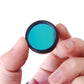 UHC filter held by fingers; circular blue-green tinted lens with black rim