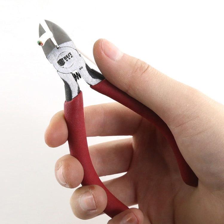 Hand holding diagonal cutting pliers with red handles and pointed jaws