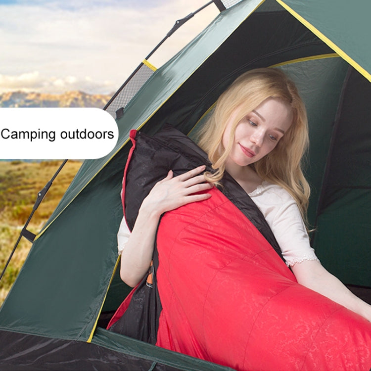 Red and black sleeping bag with hood, laid inside camping tent