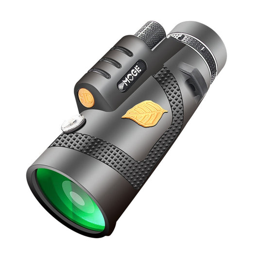 Night vision monocular telescope in dark gray with green front lens and gold badge