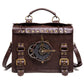 Brown leather-look crossbody bag with front gear emblem, brass hardware, and shoulder strap