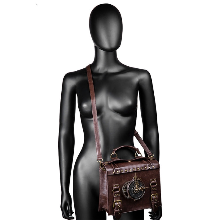 Brown leather-look crossbody bag on black mannequin with long strap and gear front emblem