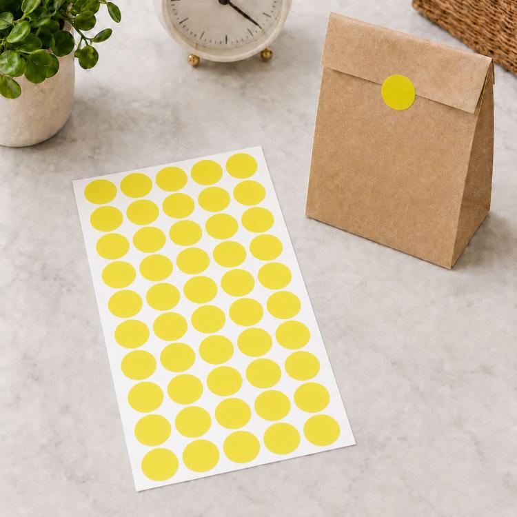 Yellow round self-adhesive sticker labels sheet with yellow dot circles on white backing