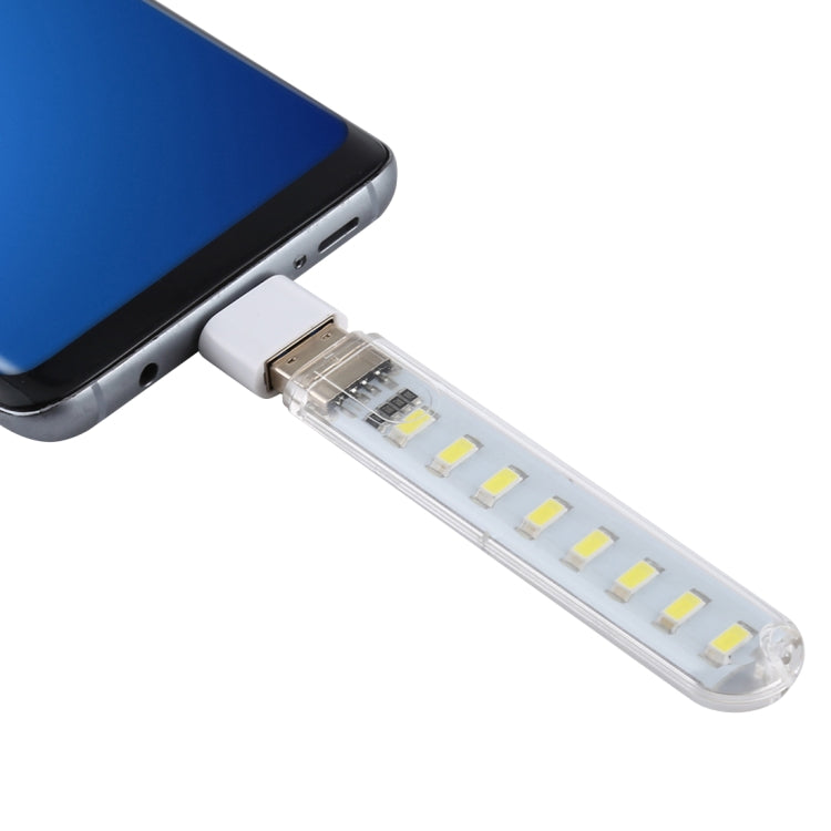 Portable USB LED book light with Type-C adapter, clipped to a phone edge