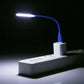 Blue flexible USB LED reading light on, white adapter block and illuminated beam