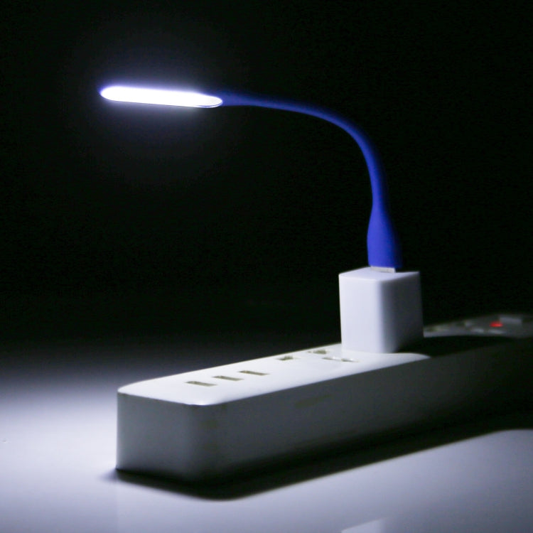 Blue flexible USB LED reading light on, white adapter block and illuminated beam