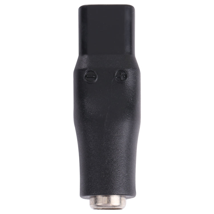 Black DC adapter end with small metal pin at the tip and molded oval housing