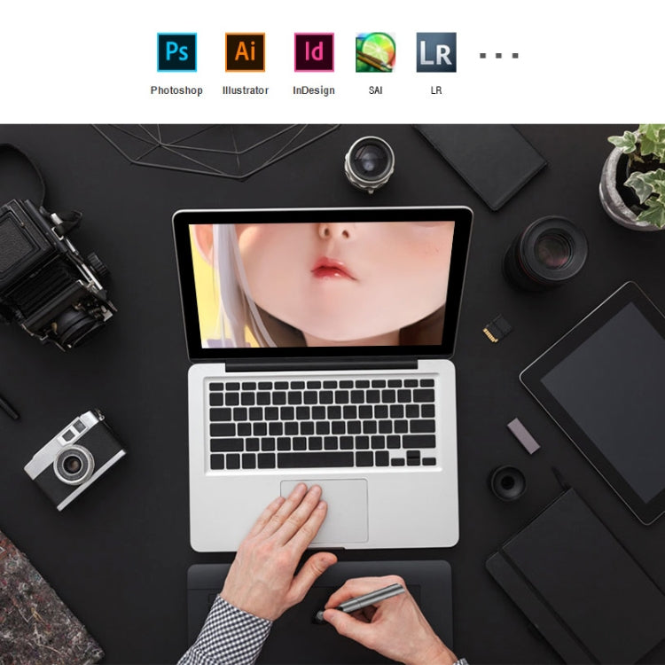 Top view electronic graphic tablet with stylus, hands, and laptop display