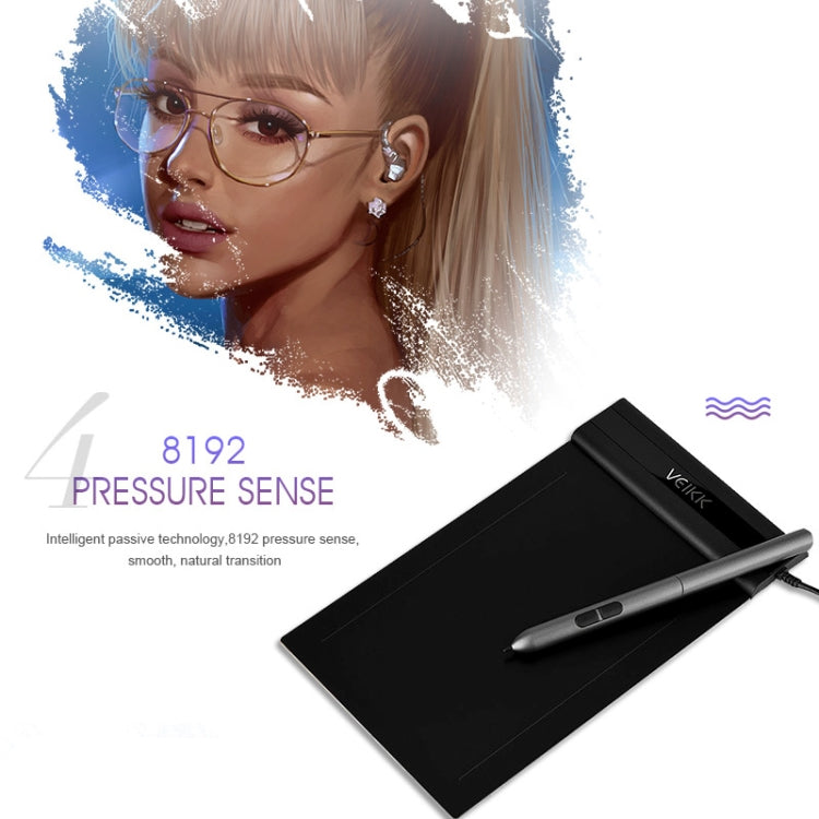 Black electronic graphic tablet with stylus pen, angled view