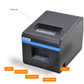 Thermal barcode printer front corner with paper exit, indicators, and blue stripe, dark gray