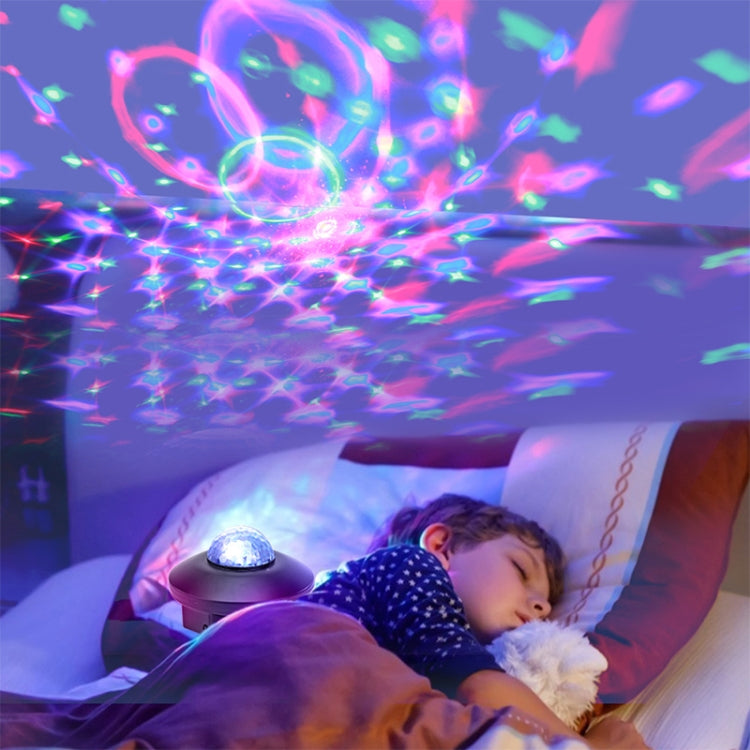 Blue dome laser star projector light beside a sleeping child, casting colorful effects