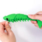 Green fish-shaped cat teething toy with rubber nubs and chew prongs, held by hands