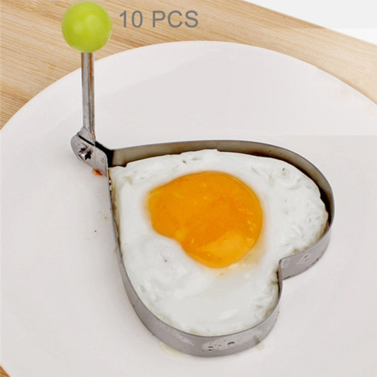 Heart-shaped omelet mold with green knob handle, holding a fried egg.