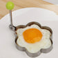 Plum-flower omelet mold with green knob handle, holding a fried egg.