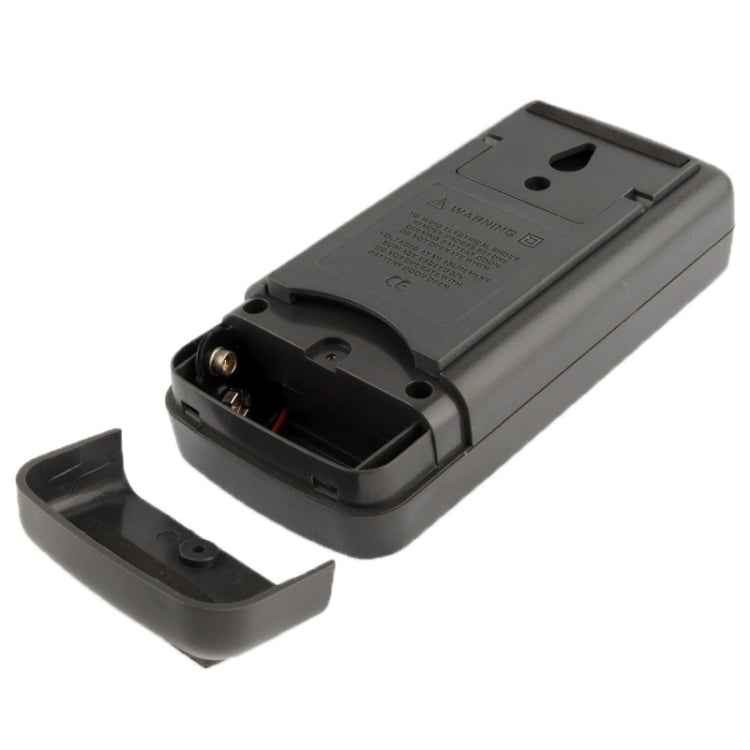 Black digital thermometer back cover removed, battery compartment and terminals visible