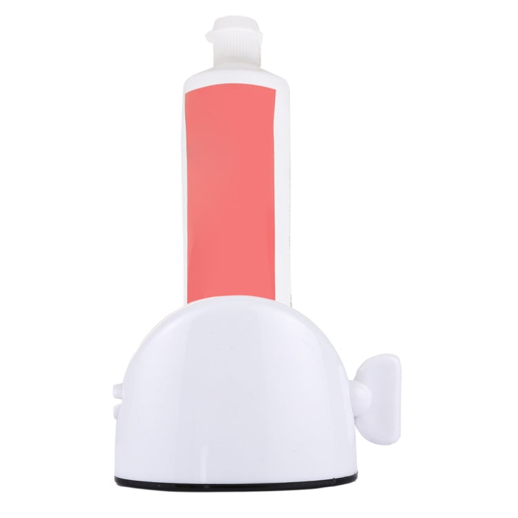 Desktop toothpaste squeezer with white base, coral-red bottle, and side lever handle