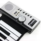 Soft keyboard piano control panel with speaker grille, knobs, and button row