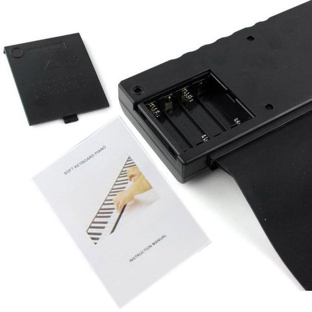 Soft keyboard piano battery compartment cover and included printed instruction card