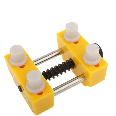 Yellow watch opener tool with three white posts and two metal guide rods