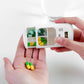 Smart pill reminder timer box in hands, showing green and yellow tablets