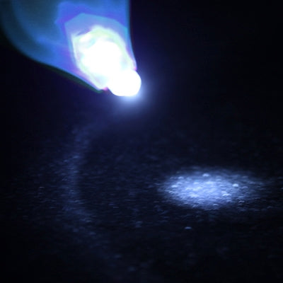 Mini LED flashlight shining a bright white beam in the dark