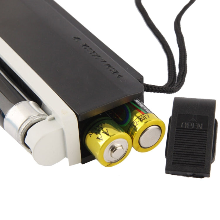 Open back of handheld UV blacklight showing battery compartment and internal components