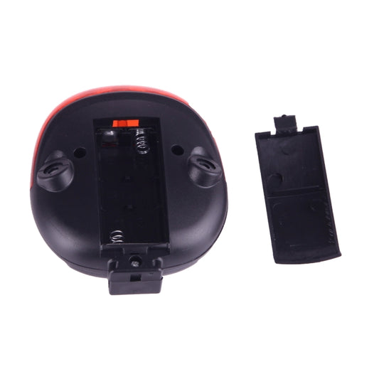 Black underside of LED bicycle tail light with battery compartment and mounting clip.