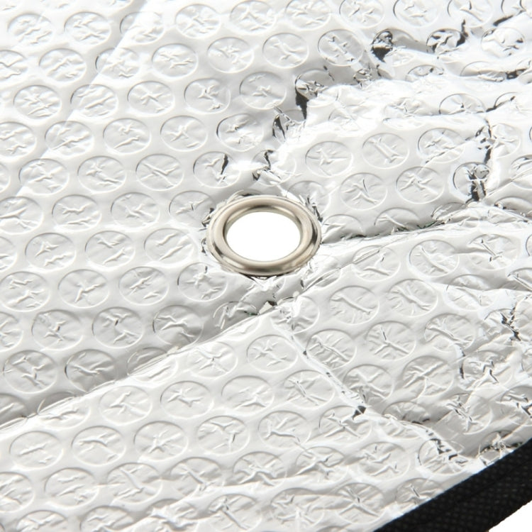 Rear windshield sunshade foil detail with round grommet on reflective silver fabric