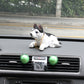 Black-and-white plush husky car decoration with gold chain, sitting on dashboard