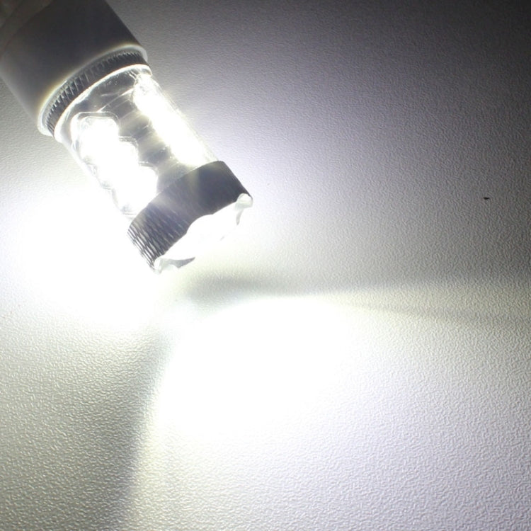 LED fog light bulb glowing white on a surface, chrome heat sink and white base