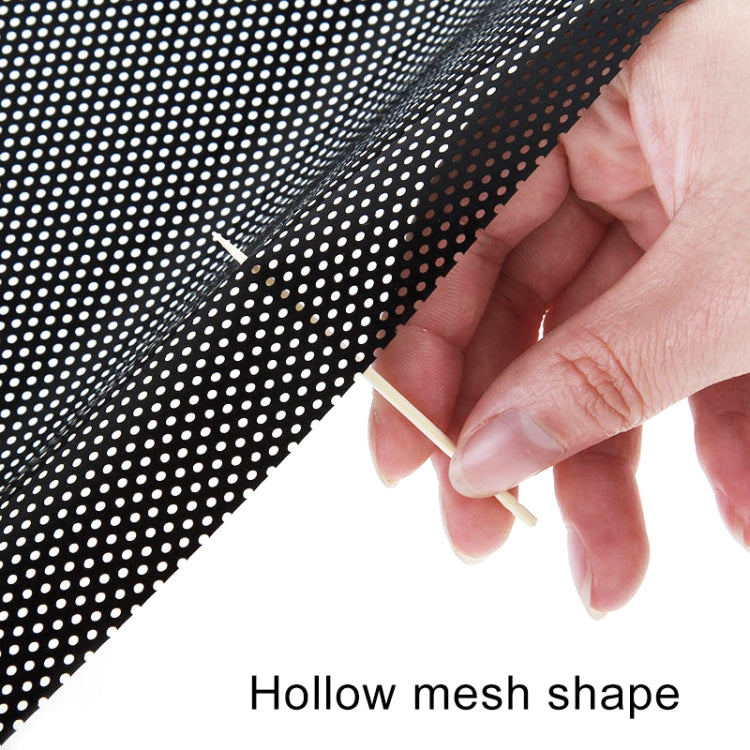Perforated gray mesh sticker being pressed onto car window by hand