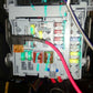 Auto fuse tap adapter installed in vehicle fuse box with red wire leading out