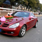 Red convertible car with pink flower decoration on the hood