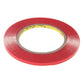 Red double-sided adhesive tape roll with visible clear inner liner