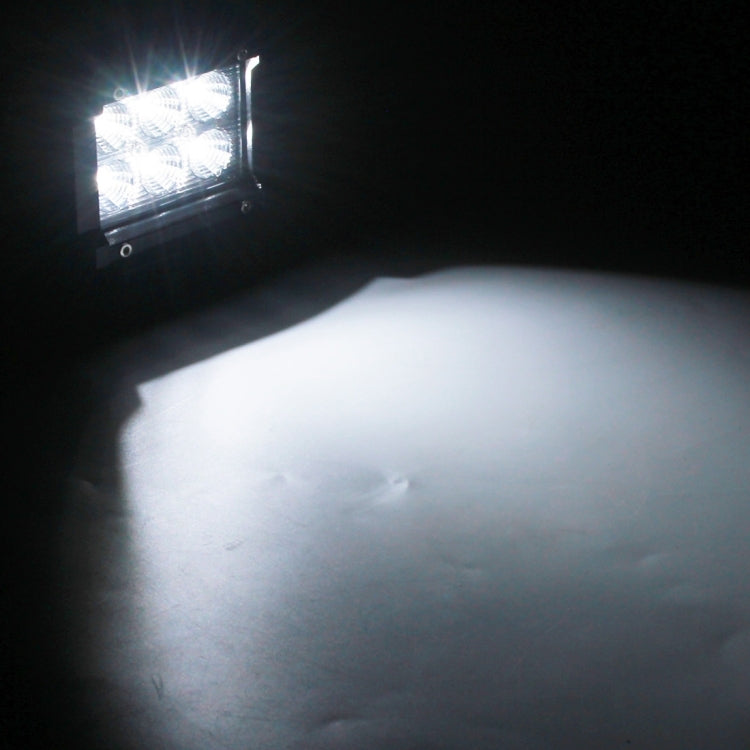 Bright white LED floodlight casting a light beam on dark ground