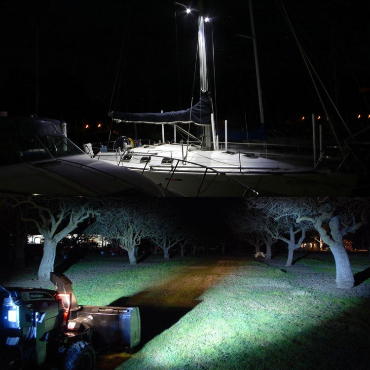 LED work light casting a bright beam onto ground near a boat at night.