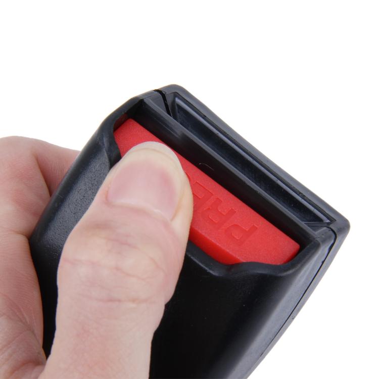 Hand holding black seat belt extension buckle; red PRESS latch window visible
