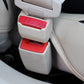 Car seat belt extension buckle with red PRESS button and black housing on seat
