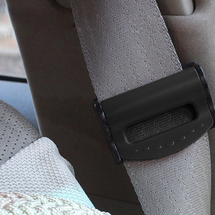 Black car seat belt adjuster clamp attached to a gray seat belt strap