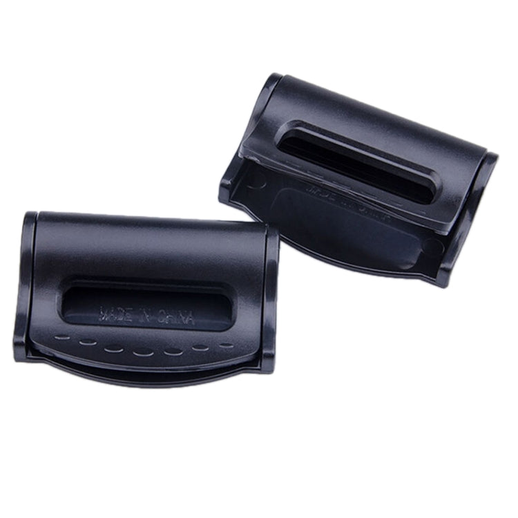 Two black car seat belt adjuster clamps with oval cutout windows