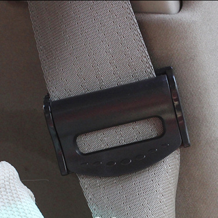 Black car seat belt adjuster clamp fitted on a gray seat belt strap