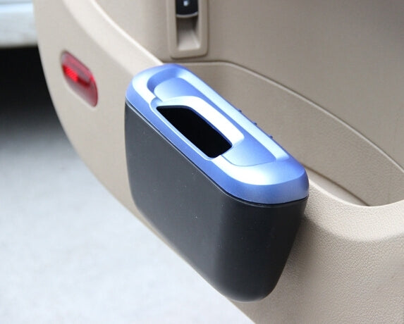Blue and black mini car storage bin beside dashboard compartment